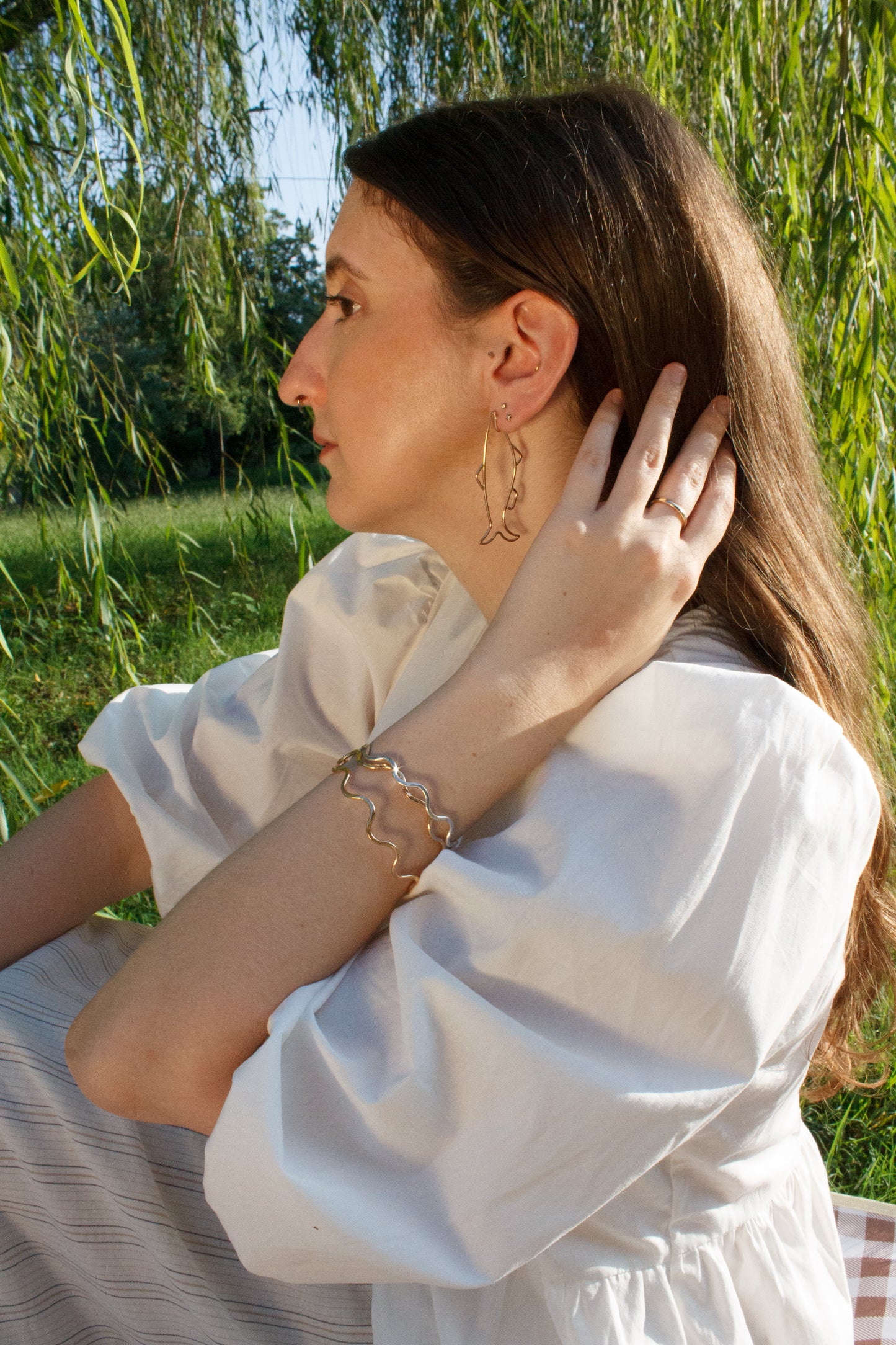 Woman in a white dress with jewelry in a natural setting